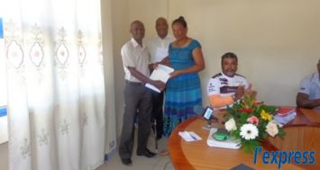 Daniel Baptiste, commissaire à la sécurité sociale (à g.), remettant un chèque de Rs 50 000 à une bénéficiaire du «plan de prestation transitoire», à Port-Mathurin.