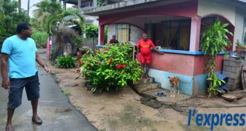 Suren Jhoorunsingh montre le niveau que l’eau, qui a pénétré dans sa maison, a atteint.