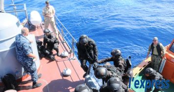 L'équipe de commandos de la National Coast Guard aborde un bateau de pêche illégal sous la supervision des officiers de l'US Navy lors d'une simulation en haute mer, le lundi 2 février.