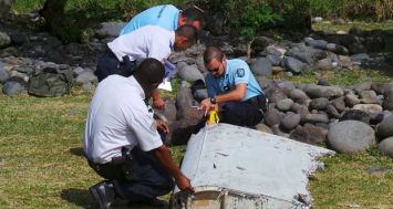Des gendarmes examinant le «flaperon» d’avion retrouvé mercredi 29 juillet à Saint-André, la Réunion.