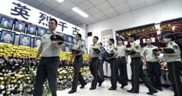 Des policiers lors d'une cérémonie d'hommage aux pompiers et soldats tués durant les explosions de Tianjin, à Tianjin le 18 août 2015. [Photo: AFP] 
