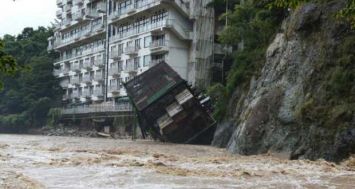 Le bâtiment d'un hôtel tombe dans les eaux d'une rivière en crue, le 10 septembre 2015 à Nikko, au nord de Tokyo. [Photo: AFP] 