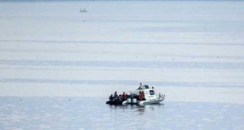 Des garde-côtes turcs interpellent des migrants qui essaient d'atteindre l'île grecque de Kos au sud-ouest de la Turquie le 15 août 2015. [Photo: AFP] 