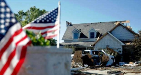 Des drapeaux américains ont été placés sur la boîte aux lettres d'une maison de Coal City (Illinois), le 23 juin 2015, au lendemain du passage d'une tornade. [Photo: AFP]