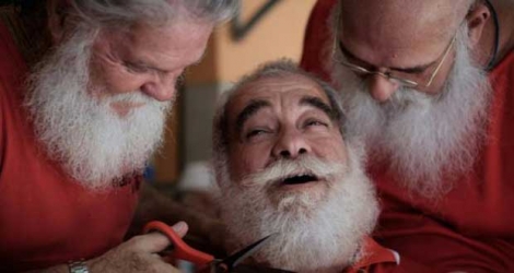 Un diplômé de l'Ecole de Père Noël brésilienne se fait tailler la barbe par un autre élève à Rio de Janeiro, le 28 décembre 2015.