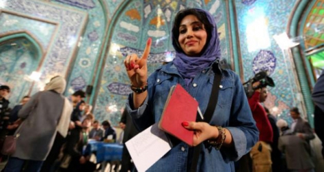 Une femme iranienne montre son doigt encré après avoir voté le 26 février 2016 à Téhéran.