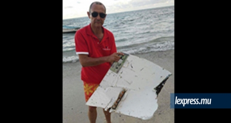 Jean Dominique Vitry tenant le débris découvert sur la plage de Var-Brûlé à Rodrigues, mercredi 30 mars.