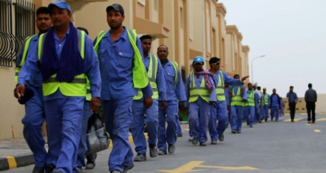 Des travailleurs immigrés de retour d'un site de construction du Mondial 2022 au Qatar, le 4 mai 2015 à Doha.