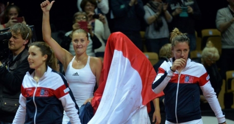Alizé Cornet, Kristina Mladenovic, Caroline Garcia (couverte d'une Tricolore) et Pauline Parmentier célèbrent la victoire française face aux Pays-Bas en demi-finale de Fed Cup, le 17 avril 2016 à Trélazé.