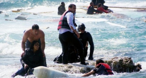 Des migrants secourus par des habitants après le naufrage de leur embarcation le 20 avril 2015 au large de Rhodes en Grèce 