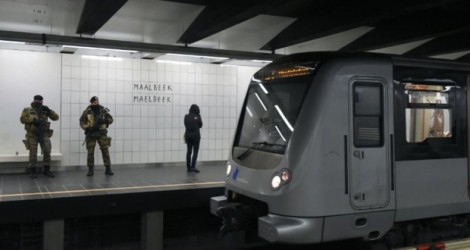 Des militaires belges montent la garde, le 25 avril 2016 à la station de métro Maelbeek à Bruxelles, à sa réouverture un mois et trois jours après les attentats jihadistes qui ont frappé la capitale belge, faisant 32 morts et des centaines de blessés.