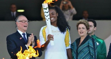 La volleyeuse brésilienne Fabiana Claudino brandit la flamme olympique aux cotés de la Mme Dilma Rousseff et Carlos Nuzman du comité d'organisation des JO de Rio, le 3 mai 2016 à Brasilia