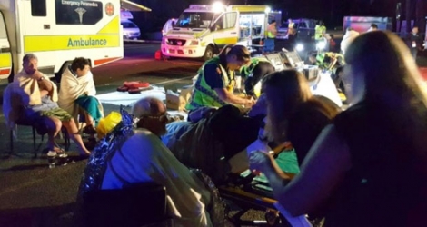 Photographie prise le 11 mai 2016 par le service d'ambulance du Queensland et reçue le lendemain, montrant le personnel médical s'occupant des touristes dont le bateau s'était enflammé près de Lady Musgrave en Australie.