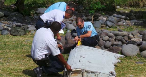 (Photo d’archives) Des gendarmes examinant le «flaperon» d’avion retrouvé mercredi 29 juillet à Saint-André, la Réunion.