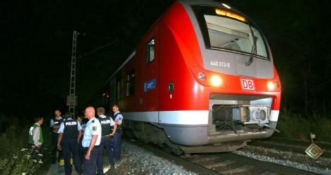 Des policiers allemands se tiennent près du train où a eu lieu l'attaque à la hache, à Würzburg, en Allemagne, le 18 juillet 2016 