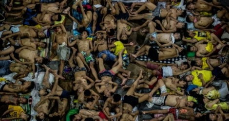Des détenus dorment les uns sur les autres sur le terrain de basket de la prison surpeuplée de Quezon City, à Manille, le 19 juillet 2016
