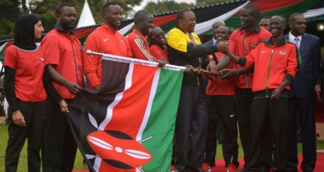 Les athlètes kényans autour de leur président Uhuru Kenyatta (jaune), lors de la remise du drapeau en vue des JO-2016, le 22 juillet à Nairobi.
