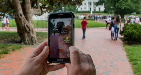 Une femme tenant dans les mains son smartphone en jouant au Pokémon Go à Washington.
