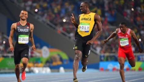 Usain Bolt échange un sourire avec le Canadien Andre de Grasse à l'arrivée de leur demi-finale du 200 m aux Jeux de Rio, le 17 août 2016