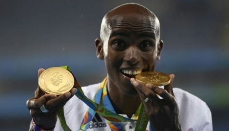 Le Britannique Mo Farah pose avec ses 2 médailles d'or après ses victoires sur 10.000 et 5000 m, aux JO de Rio, le 20 août 2016 
