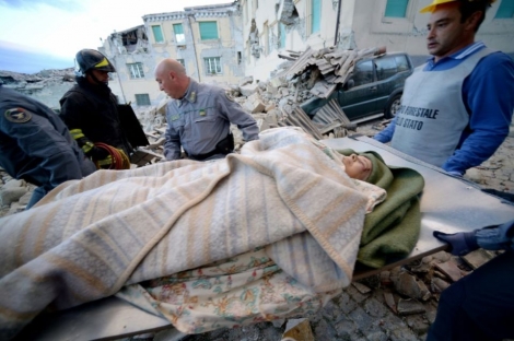 Des sauveteurs transportent un homme à Amatrice, dans le centre de l'Italie, après un fort séisme, le 24 août 2016 
