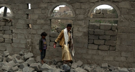 Des Yéménites traversent les décombres d'une maison détruite par une frappe aérienne de la coalition saoudienne à Sanaa, la capitale aux mains des rebelles.