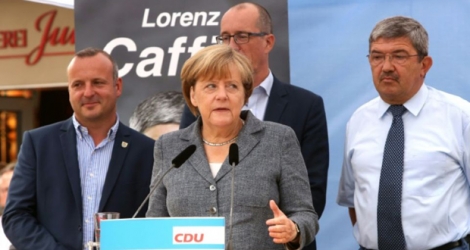 La chancelière allemande Angela Merkel à côté du ministre de l'Intérieur de Mecklembourg-Poméranie occidentale Lorenz Caffier (droite) et le candidat de la CDU Christian Democratic, lors d'un meeting de campagne à Bad Doberan (est), le 3 septembre 2016.