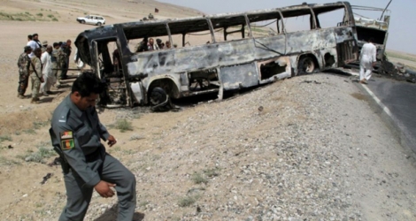 Un policier inspecte le site de la collision d'un autocar et d'un camion-citerne dans la province de Kandahar.