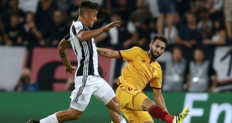 L'attaquant argentin de la Juventus Paulo Dybala bute sur un défenseur de Séville à Turin, le 14 septembre 2016.