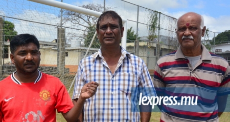 Oomesh Ramlugun (à g.) et Dass Thimmadu, respectivement président et membre du conseil de village, entourent Rakesh Busgeeth, président du club sportif Bonair.