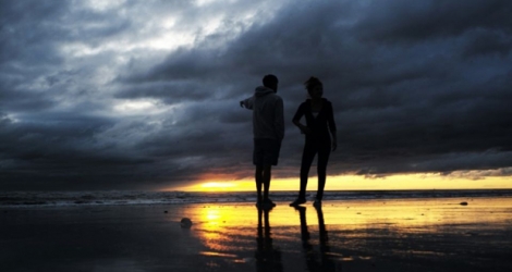 Un couple se promène à l'aube à Jacksonville Beach, e, Floride, après le passage de l'ouragan Matthew, le 8 octobre 2016.
