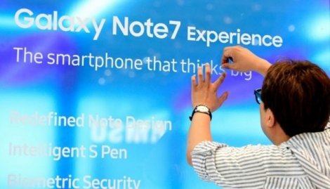 Un homme colle une affiche publicitaire pour le smartphone Samsung Galaxy Note7 à Berlin le 2 septembre 2016