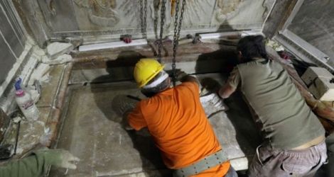 Des scientifiques replacent la plaque de marbre recouvrant la tombe que les chrétiens considèrent comme celle de Jésus dans l'église du Saint Sépulcre à Jérusalem, le 28 octobre 2016.