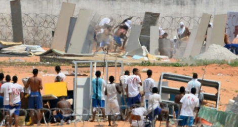 Des prisonniers se protègent de tirs de balles en caoutchouc de policiers lors d'une émeute dans la prison d'Alcaçuz, au Brésil, le 17 janvier 2017. 
