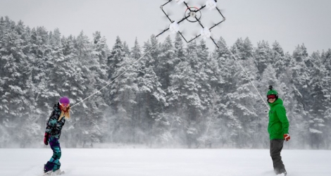 Reliés à l'aide de longues cordes à ce drone puissant, long de trois mètres, les deux snowboarders se lancent dans une série de virages et de glissades à haute vitesse.