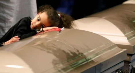 Une petite fille se couche sur le cercueil de l'une des trois victimes de la fusillade de la mosquée de Québec le 3 février 2017