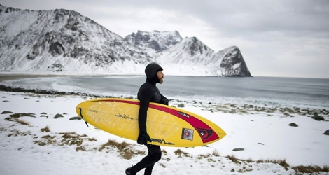 La légende australienne du surf, Tom Carroll, s'apprête à affronter les vagues glacées de l'Artique, le 9 mars 2017 à Unstad (Norvège)