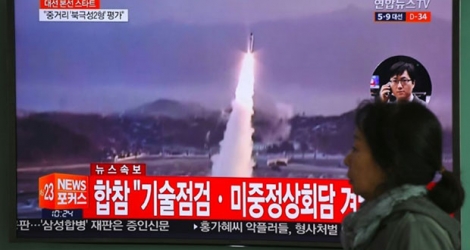 Une femme passe devant un écran de télévision montrant un nouveau tir de missile en Corée du nord, le 5 avril 2017 à Séoul 