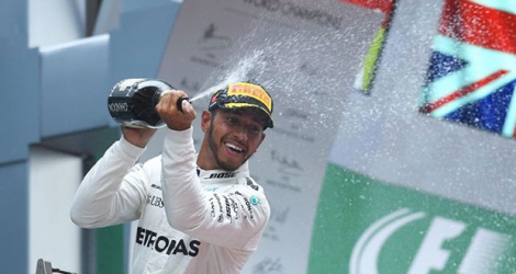 Le Britannique Lewis Hamilton en liesse sur le podium après sa victoire au GP de Chine.