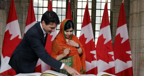 Malala Yousafzai signe un livre d'or avec Justin Trudeau, au Parlement à Ottawa le 12 avril 2017 .