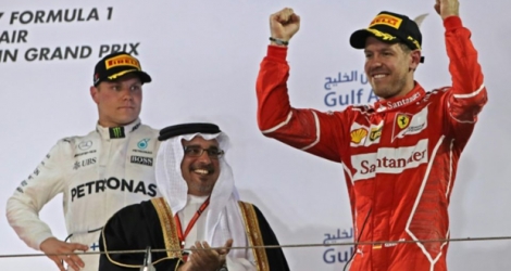 Le pilote allemand Sebastian Vettel (Ferrari) bras levés sur le podium après sa victoire au Grand Prix de Bahreïn sur le cicuit de Sakhir, le 16 avril 2017.