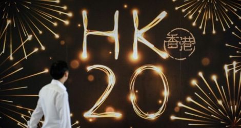 Le 20 avril 2017, à Hong Kong, un homme regarde une affiche célébrant les 20 ans de la rétrocession de Hong Kong à la Chine par le colonisateur britannique.