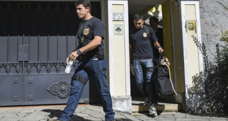 Les inspecteurs de la police fédérale brésilienne emportent des documents après la perquisition, le 5 septembre 2017 de la résidence de l'ex-patron de Rio-2016