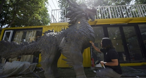 L'artiste chinois Sun Shiqian devant l'une de ses créations, un dragon de métal de près de 5 mètres de haut, le 29 août 2017 dans son atelier de la banlieue de Pékin