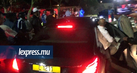 Le ministre Etienne Sinatambou se précipitant à bord de la voiture d’Ivan Collendavelloo après une réunion houleuse avec des habitants de Résidence Barkly, lundi 4 septembre.