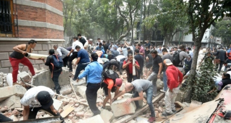 Des mexicains déblaient les débris d'un bâtiment endommagé par un tremblement de terre à Mexico, le 19 septembre 2017.