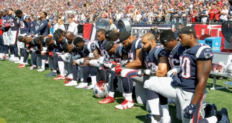 Des joueurs des New England Patriots, agenouillés au bord du terrain quelques heures après que Donald Trump a proposé de boycotter les équipes dont les joueurs 