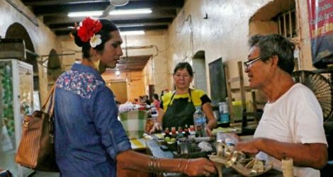Estrella Velazquez (g), un «muxe» (homosexuel habillé en femme), discute avec un cordonnier à Juchitan de Zaragoza, le 26 juillet 2017 au Mexique .