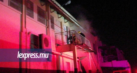 Les pompiers enfonçant la porte d'un entrepôt de Shoprite qui a pris feu hier.