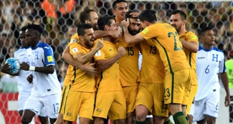 Le milieu de l'Australie Mile Jedinak (c) est congratulé par ses équipiers après son but face au Honduras en qualif pour le Mondial-2018, le 15 novembre 2017 à Sydney.